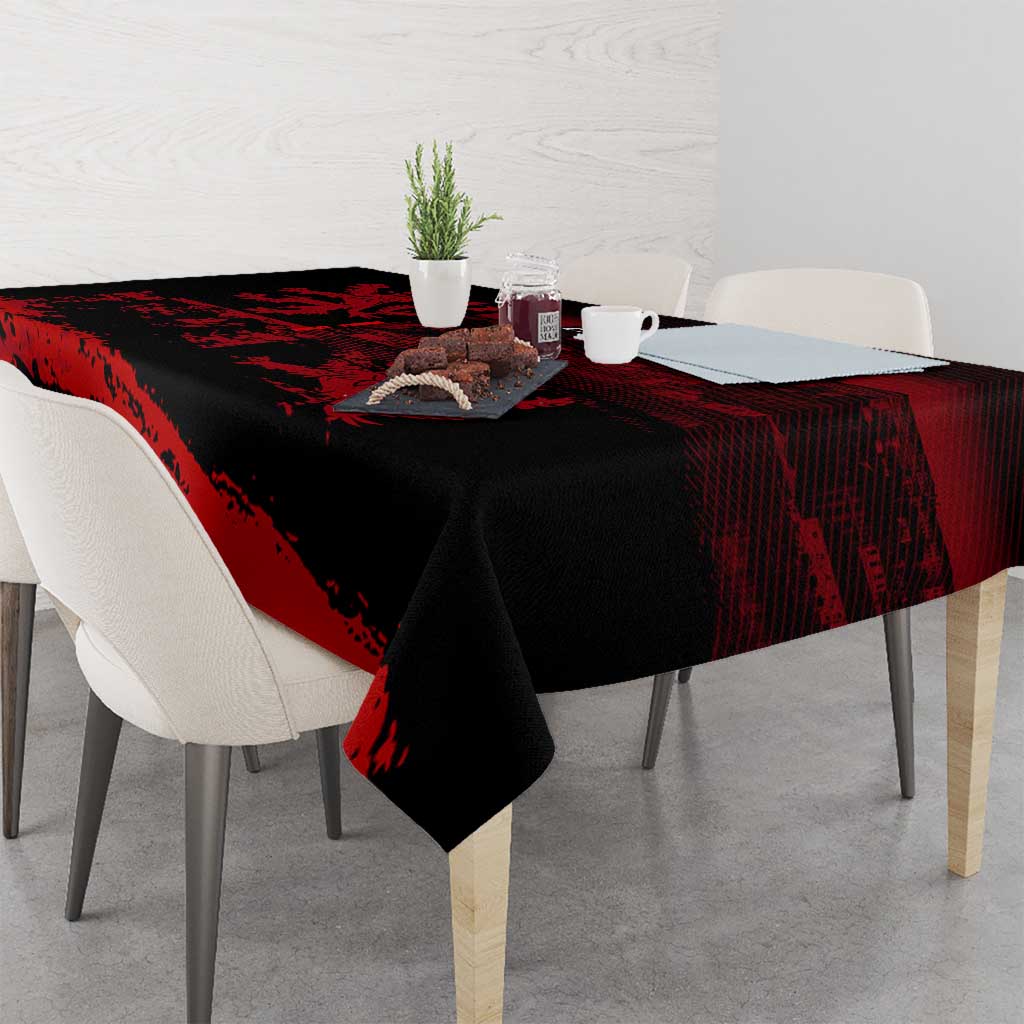Draped black tablecloth with red lion crest pattern over rectangular tabletop