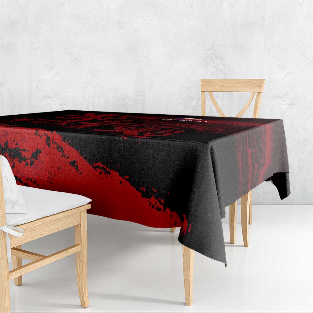 Black tablecloth with red diagonal lion graphic, corner over wooden bench