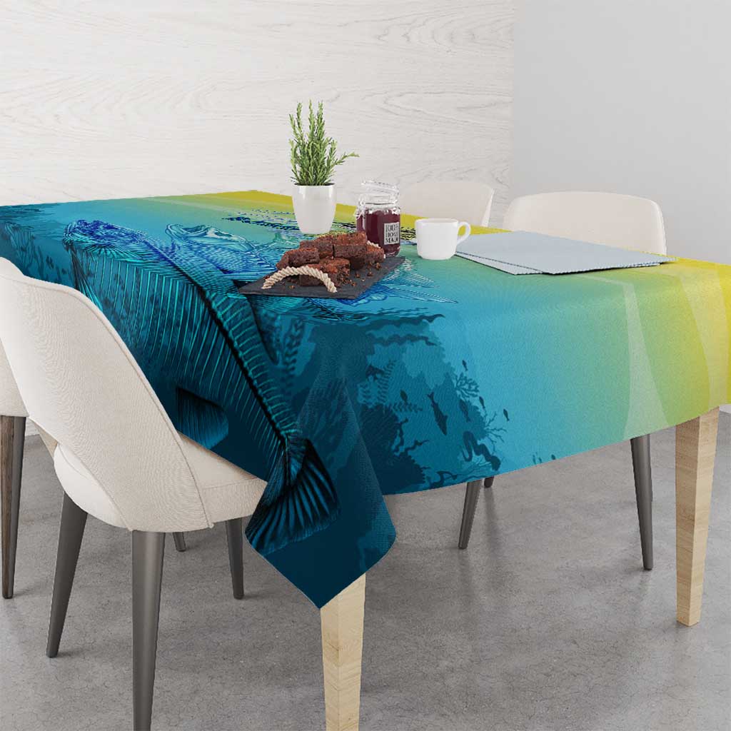 Blue and yellow fish tablecloth draped on dining table with printed fish and fins