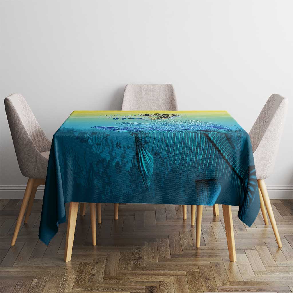 Teal-blue fish tablecloth with yellow gradient top, draped over dining table