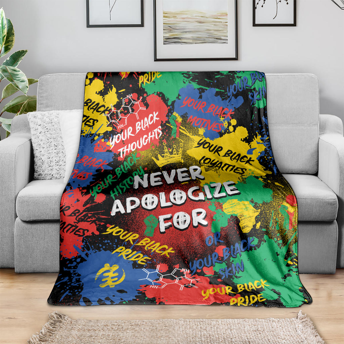 Multicolor graphic throw blanket with large white lettering, draped on sofa