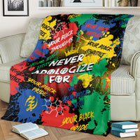 Multicolor printed blanket with bold white text, draped over couch seat