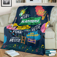 Dark blue African blanket with colorful music-themed design on couch with books nearby