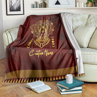 Red personalized Anubis-themed blanket with gold detailing and striped border on bed