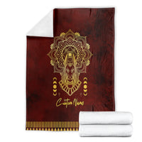 Red Anubis-themed personalized blanket folded with gold emblem and striped bottom border