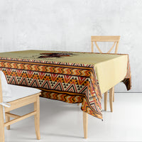 Beige tablecloth with colorful geometric trim and overhanging drape on dining table