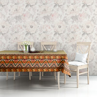 Beige tablecloth with colorful patterned border and illustrated centerpiece on table