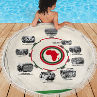 Round beige beach blanket with African timeline ring graphic and green/red map center, fringe