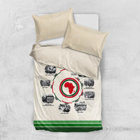 Beige bedding set flatlay with duvet and two pillows; circular African timeline print and green hem