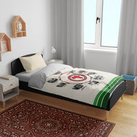 Beige duvet cover with circular African timeline emblem and green stripe edge; two pillows