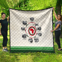 White diamond-quilted throw with circular African timeline graphic and green edge.