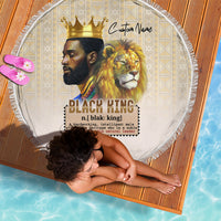 Round beige beach blanket with lion and crown graphic, fringed border