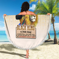 Round beige beach blanket with lion king graphic and fringed border on sand