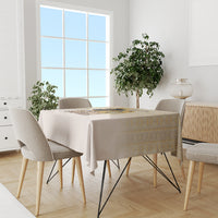 Beige tablecloth on dining table with gold geometric stripe along the edge