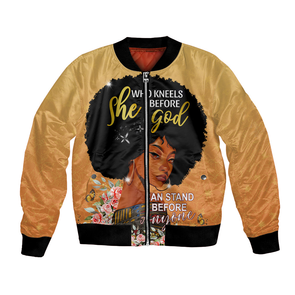 Gold bomber jacket with black front graphic portrait and "She Who Kneels Before God"