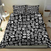 Black bedding set laid out with white Adinkra-style symbol pattern on duvet and pillows