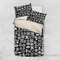 Black bedding set on white background with white Adinkra-style symbol pattern and pillows