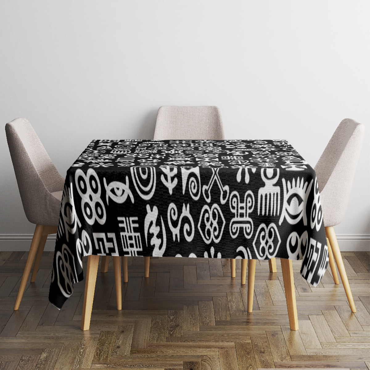 Black tablecloth with white adinkra pattern on dining table with chairs