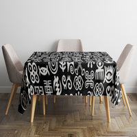 Black tablecloth with white adinkra pattern on dining table with chairs