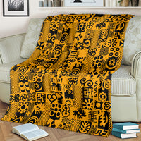 Yellow and black Adinkra pattern throw blanket on striped sofa seat