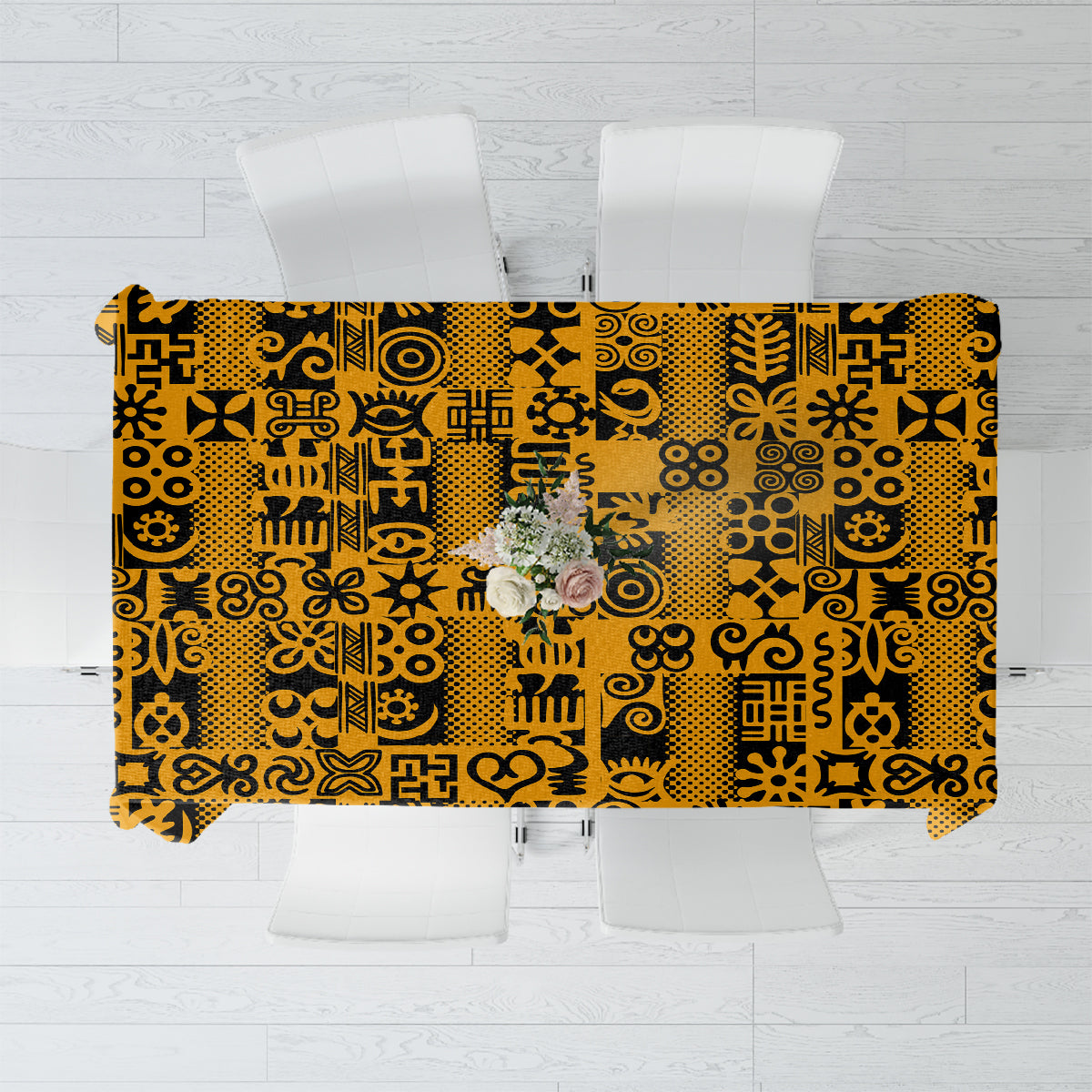 Yellow tablecloth with black Adinkra pattern, flat view spread over a table