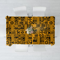 Yellow tablecloth with black Adinkra pattern, flat view spread over a table