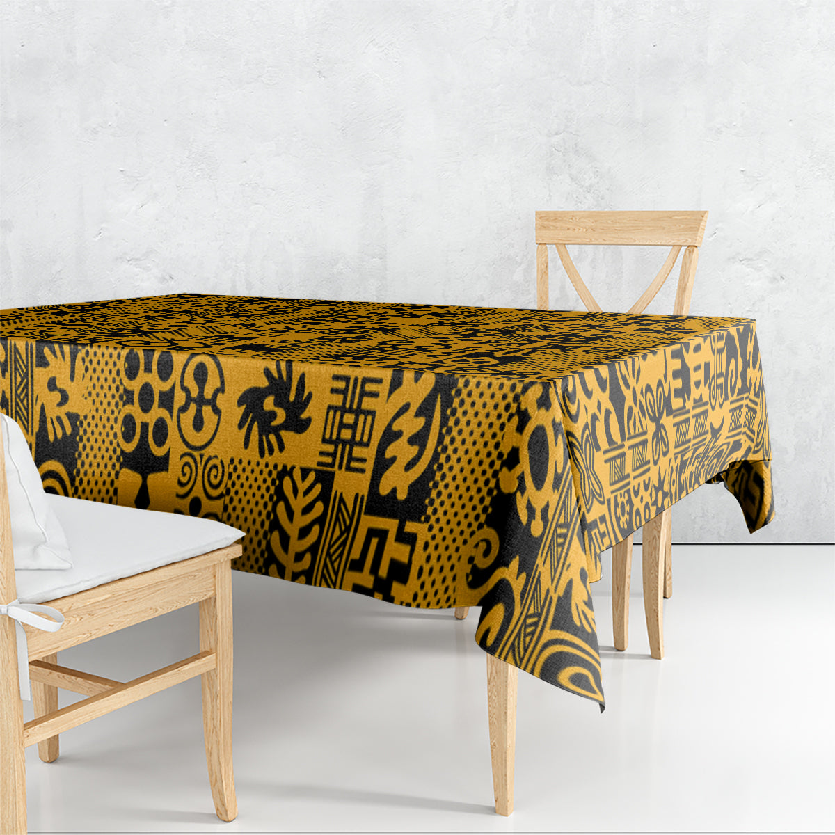 Yellow tablecloth with black Adinkra print, draped over a rectangular dining table