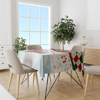 Christmas tablecloth with colorful Santa panel and red-green diamond trim on dining table