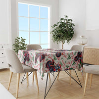 Christmas tablecloth draped over table: white with red green Santa motorbike pattern, straight hem
