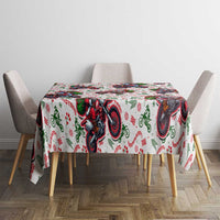 Christmas tablecloth on dining table: white fabric with red green Santa on motorbikes pattern