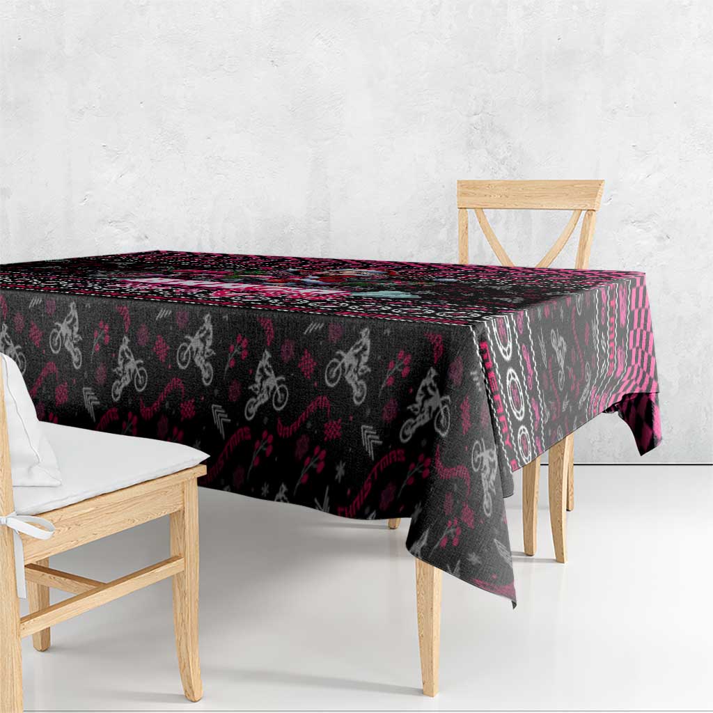 Black Christmas tablecloth draped over table edge with pink and red vertical stripe accents.