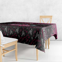 Black Christmas tablecloth draped over table edge with pink and red vertical stripe accents.
