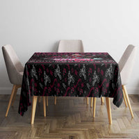 Black printed Christmas tablecloth with pink and red border pattern on dining table.