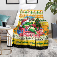 Yellow crocodile Christmas blanket shown on a sofa with side table and decor
