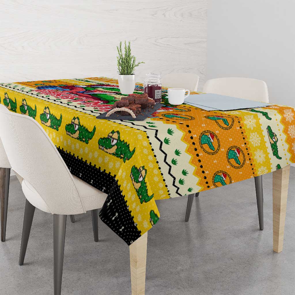 Yellow Christmas tablecloth draped over table with crocodile and holiday motifs