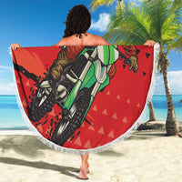 Red round beach blanket with Santa motocross print and white fringed hem, 150cm.