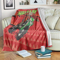 Red motocross Santa blanket with green rider graphic, draped over a couch