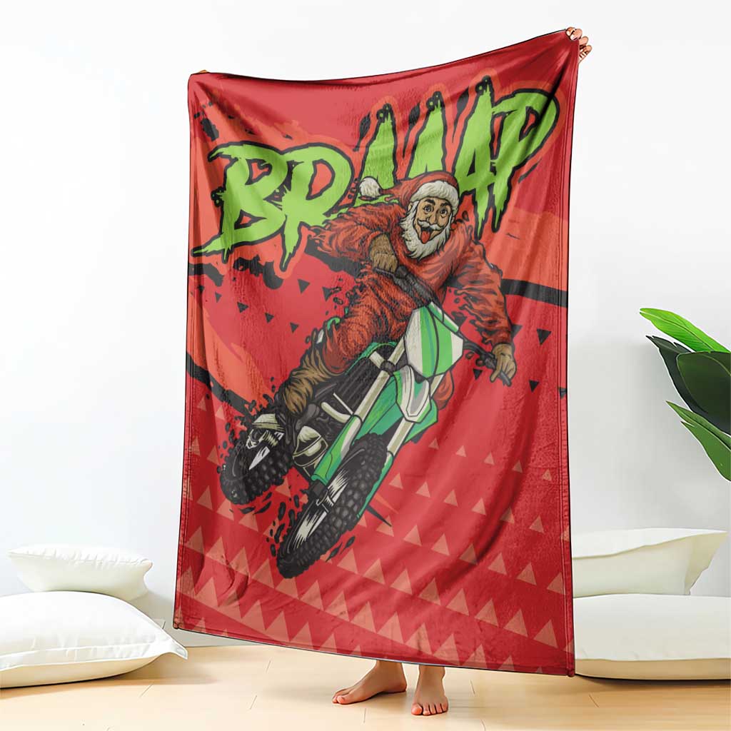 Red motocross Santa blanket with green lettering and rider, draped upright on floor