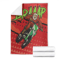 Red motocross Santa blanket with green rider graphic, shown with folded white towels