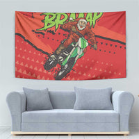 Red motocross Santa tapestry above a light gray sofa with rider graphic and green text