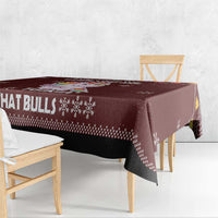 Christmas tablecloth corner, maroon with bull text and snowflake print, draped on table