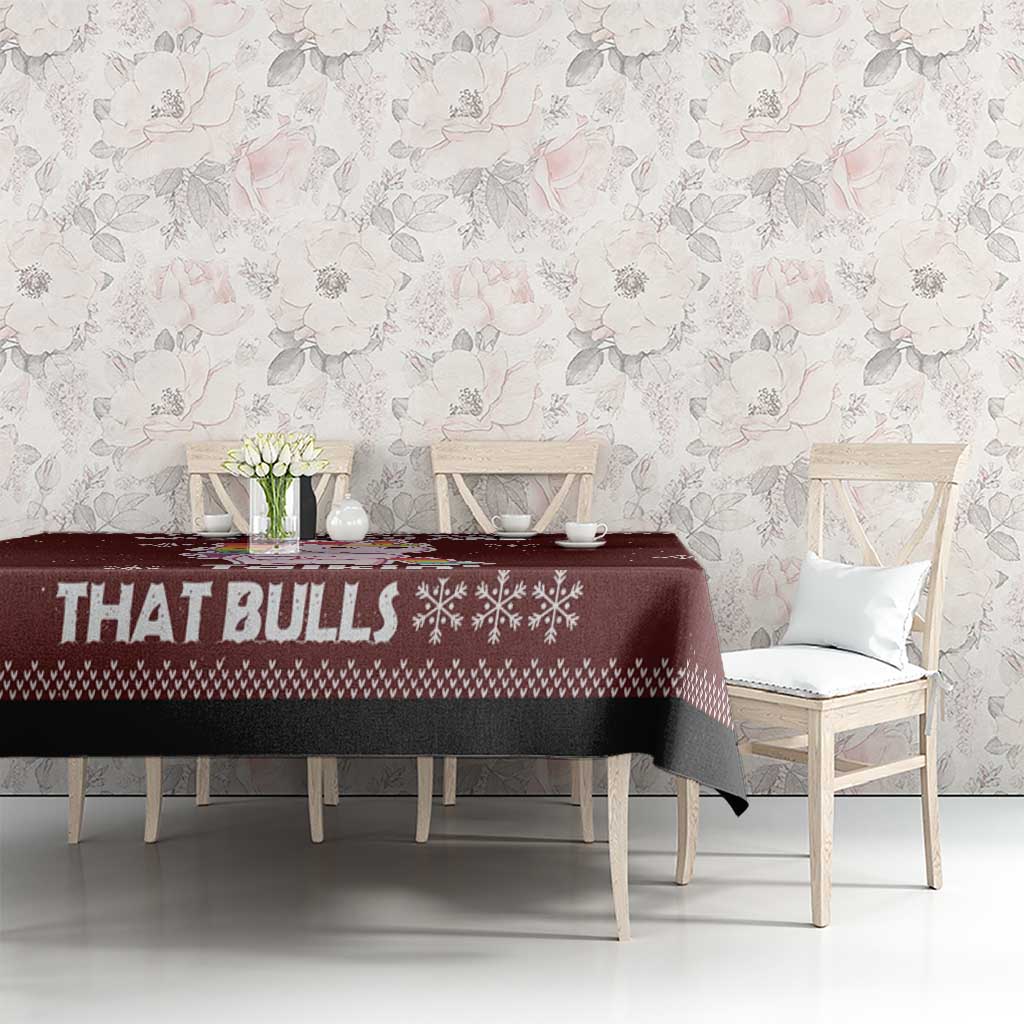 Christmas tablecloth, maroon with bull text and snowflake pattern, on dining table