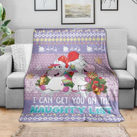 Light purple Christmas blanket spread on a couch, unicorns and “naughty list” print
