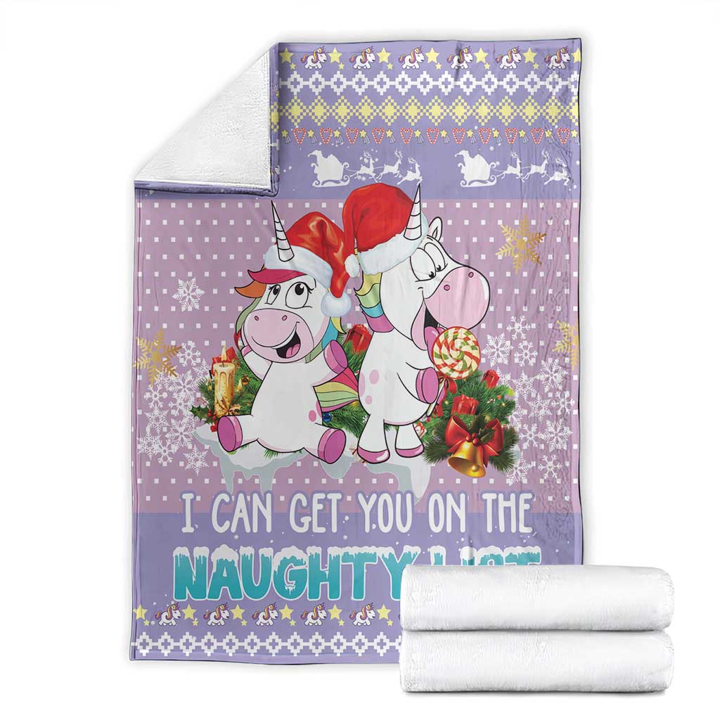 Folded light purple unicorn Christmas blanket with “naughty list” text, shown with towels