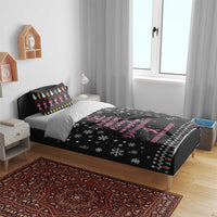 Black bedding set on bed with pink ribbon word art, white snowflake prints and trim