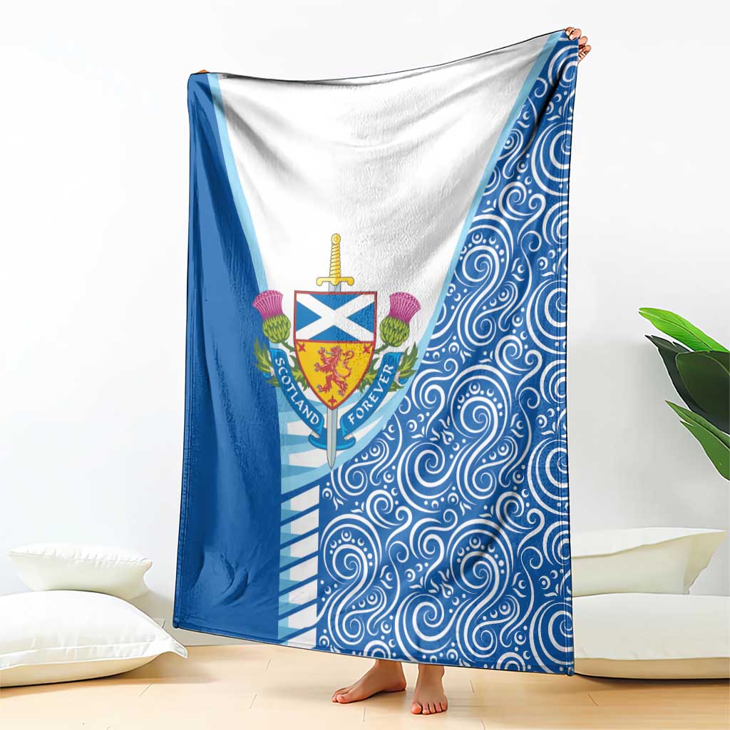 Blue and white blanket with Scotland crest and swirling wave design, draped on bed