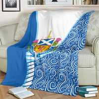 Blue and white Scotland crest blanket with swirling wave pattern, laid over couch