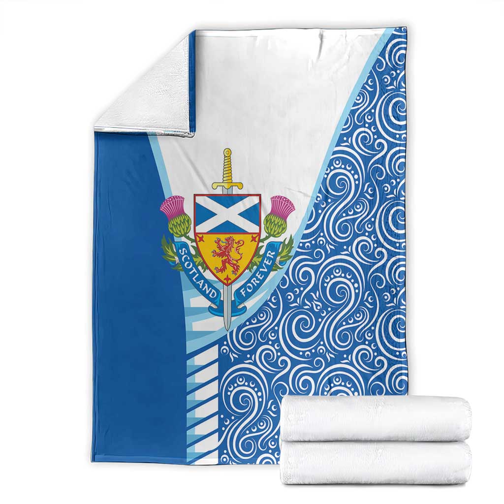 Blue and white blanket with crest logo and swirling pattern, folded with spare roll