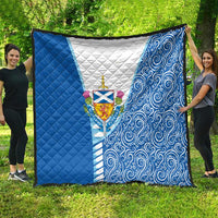 Blue quilt with white center and Scottish crest, flanked by blue swirls and solid panels