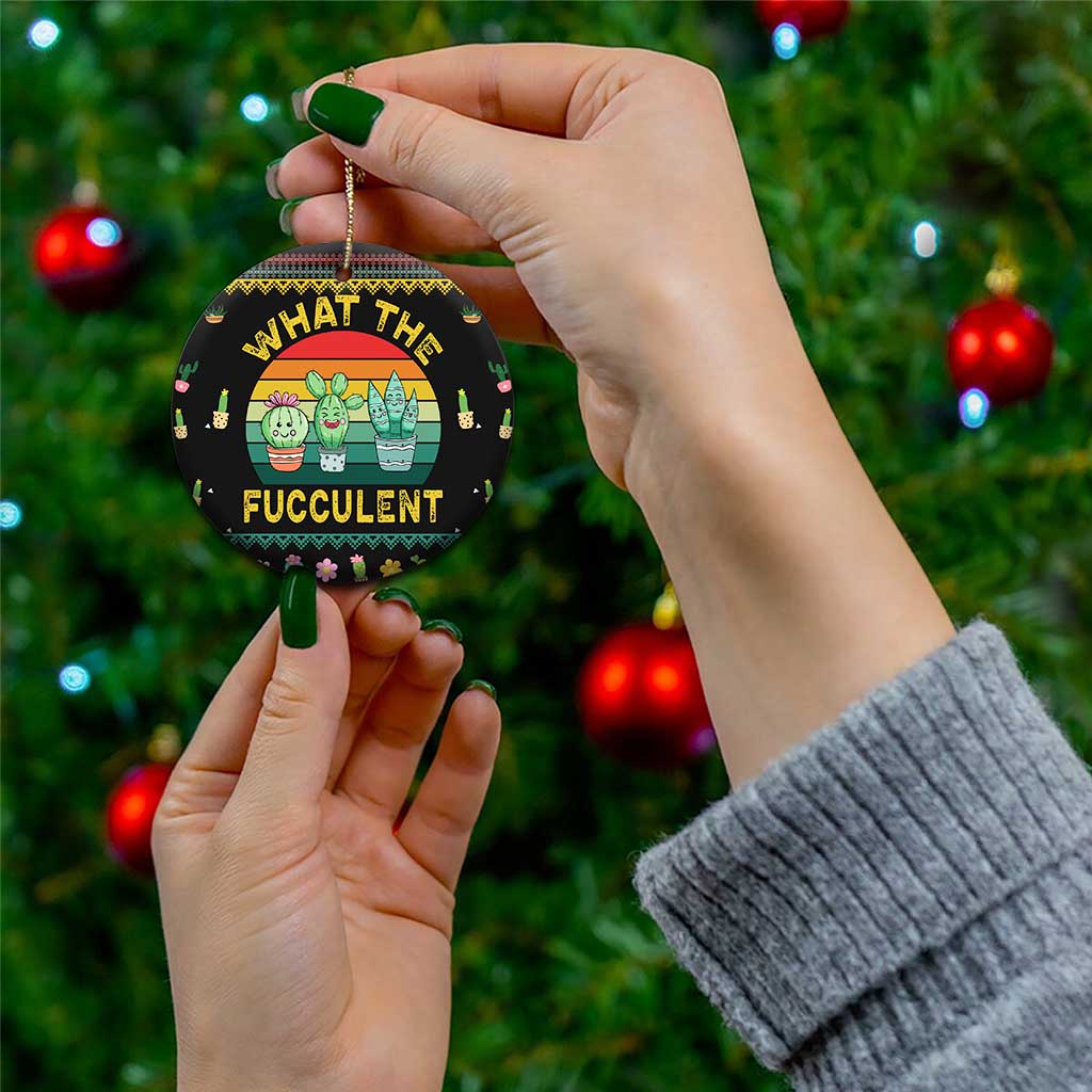 Black round cactus succulent ceramic ornament held in hand with gold hanging loop